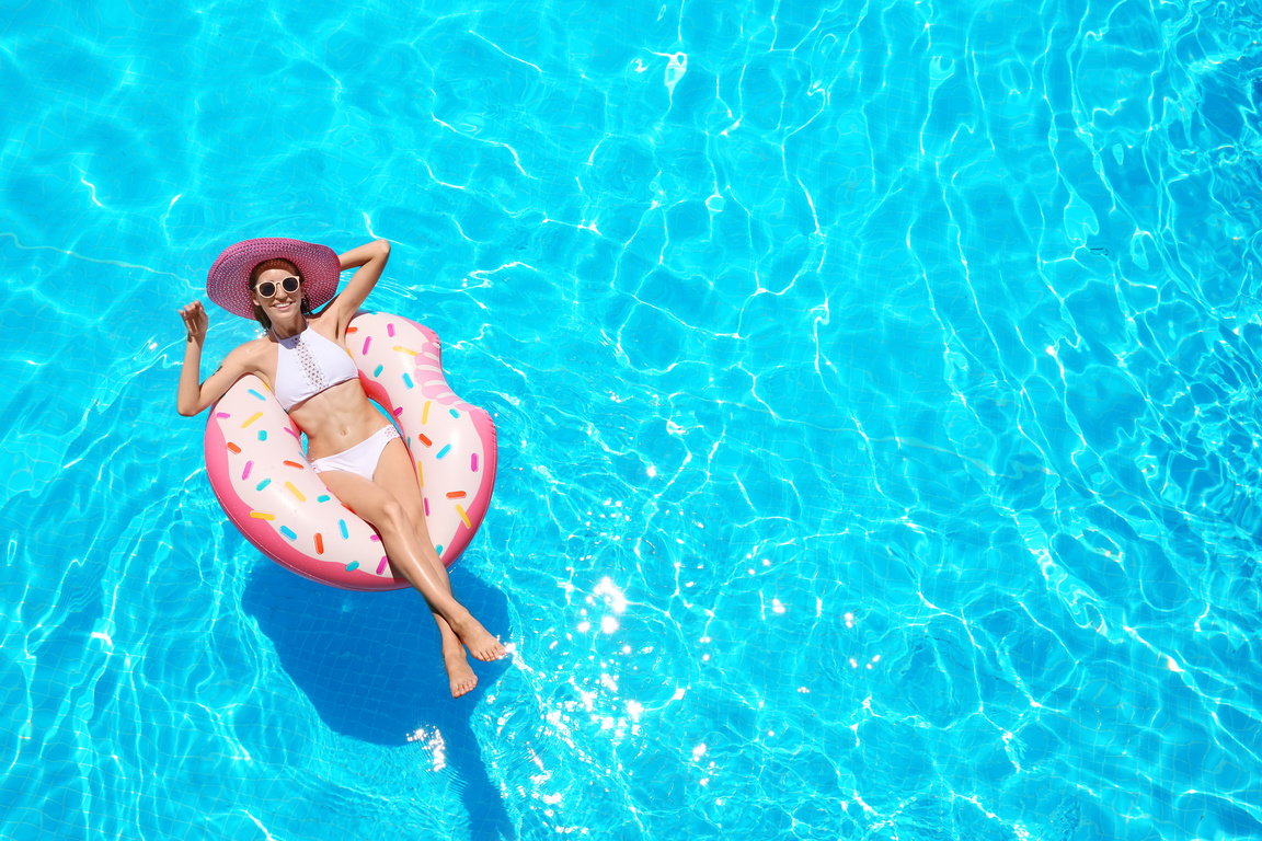 Beautiful Young Woman with Inflatable Donut in Swimming Pool